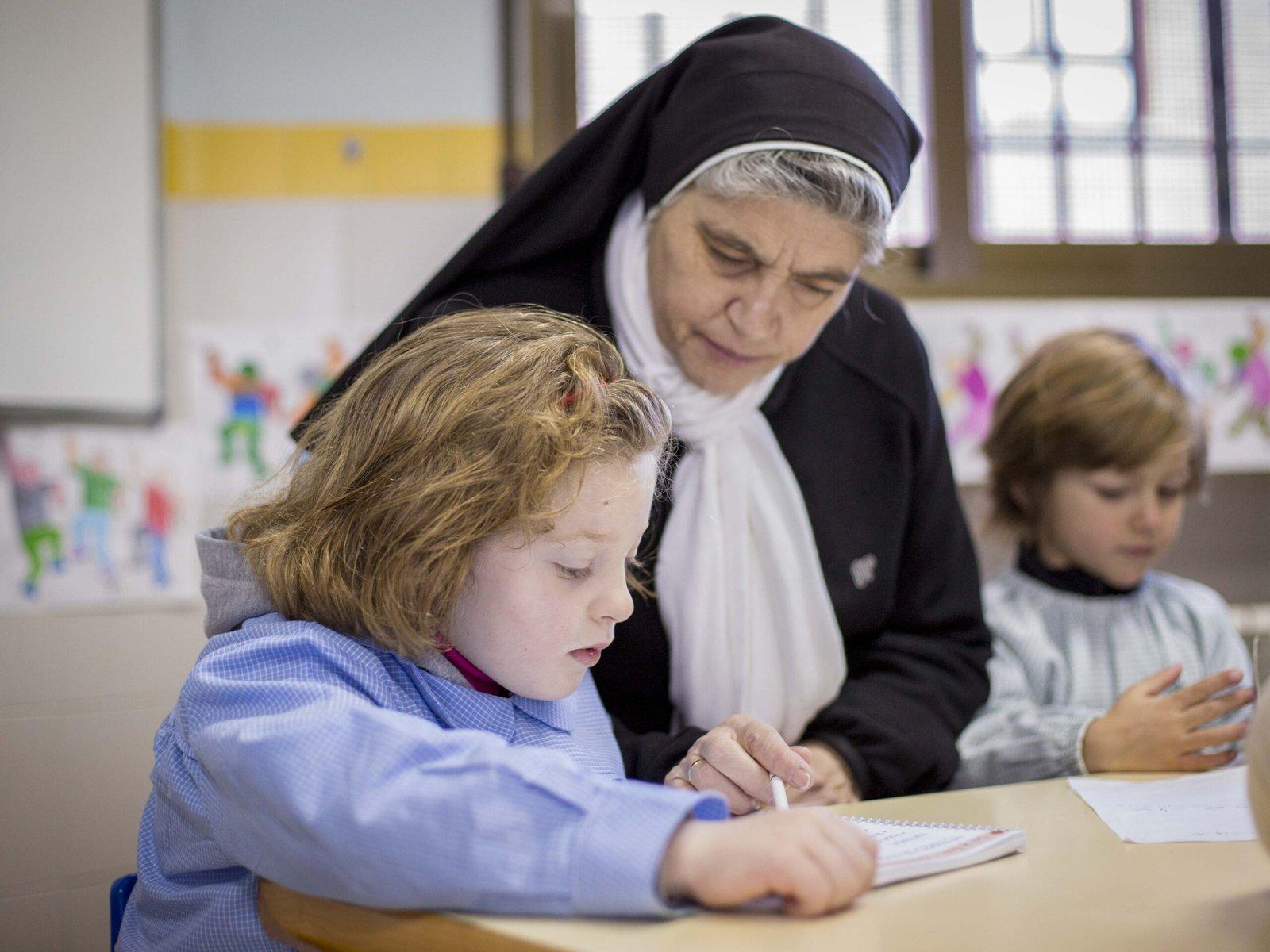 Hermana del centro acompañando a una alumna en clase